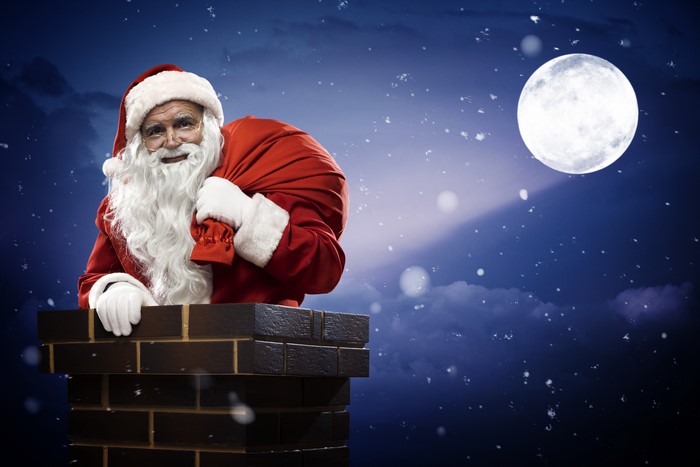 Santa Claus in a chimney with a gift bag
