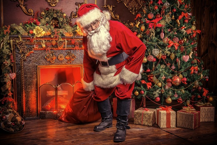 Santa Claus with Gifts by a Festive Fireplace