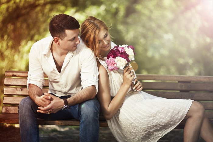 Couple sitting on a bench with flowers