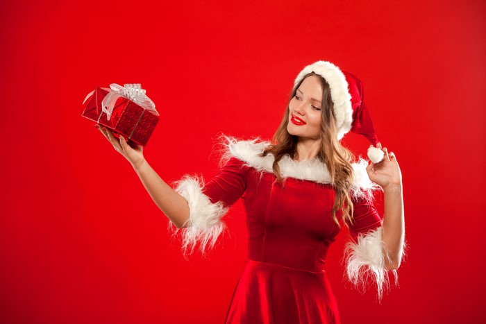 Woman in Santa costume holding a gift