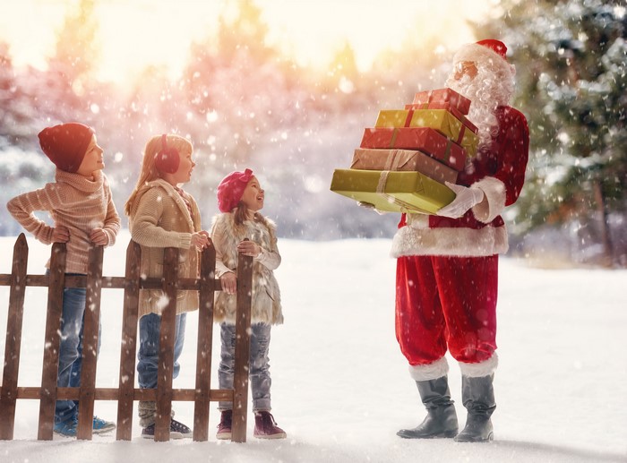 Santa Claus giving gifts to children in the snow