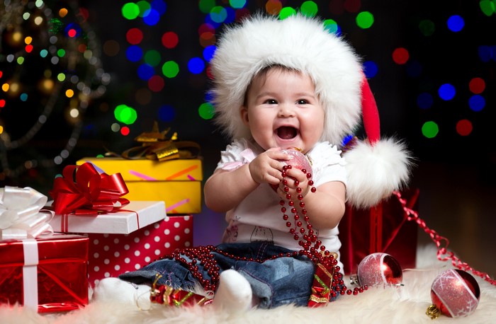 Baby in Santa hat with Christmas gifts