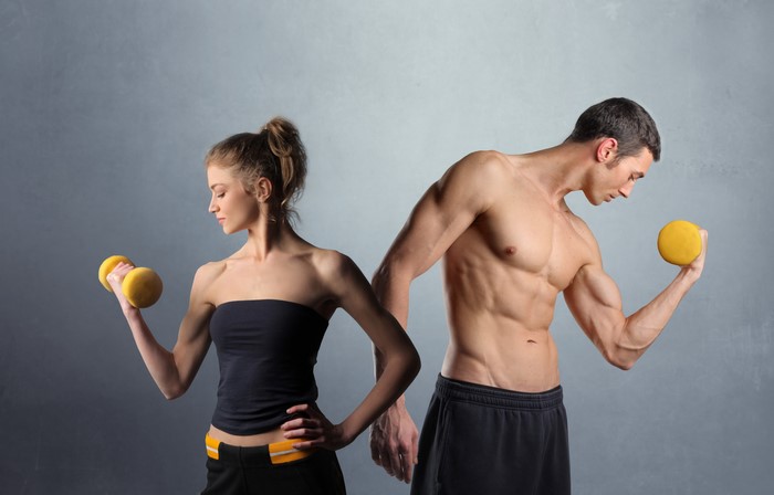 Man and woman exercising with dumbbells