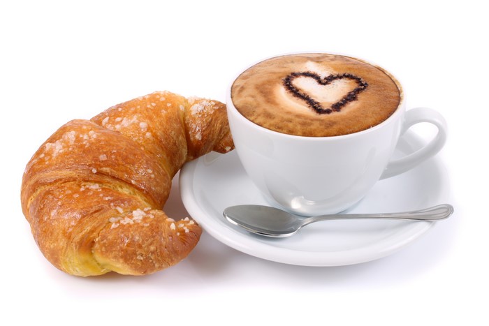 Cappuccino with heart art and croissant