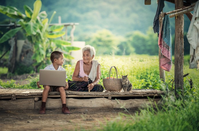 Asian boy with laptop and old woman with cat