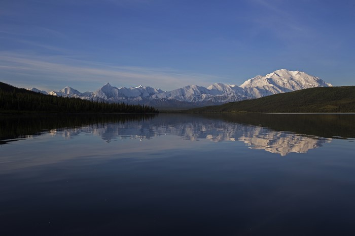 Snow-capped Denali mountains reflected in a calm lake