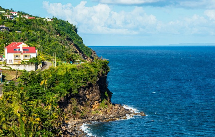 Houses on a cliff overlooking the ocean in Basse-Terre, Guadeloupe