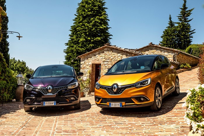 Two Renault Scenic cars parked outside a stone building