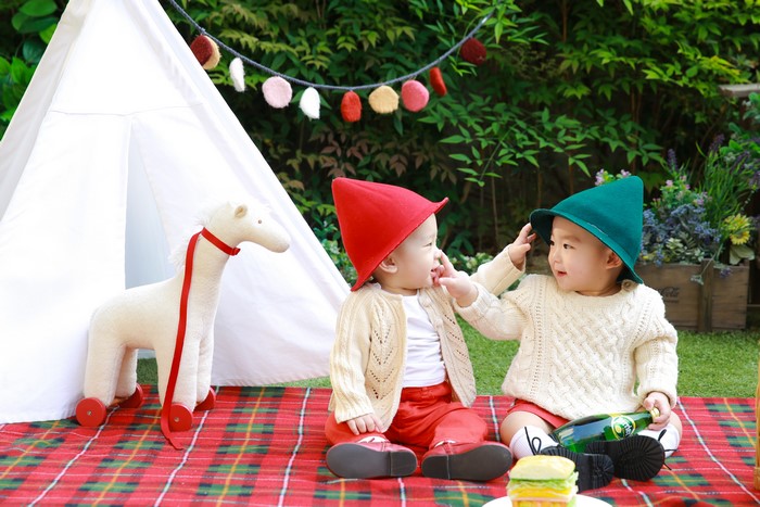 Two Asian babies in gnome hats at a picnic