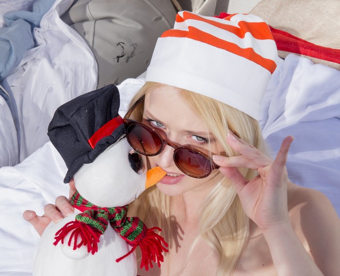 Blonde girl in winter hat with snowman