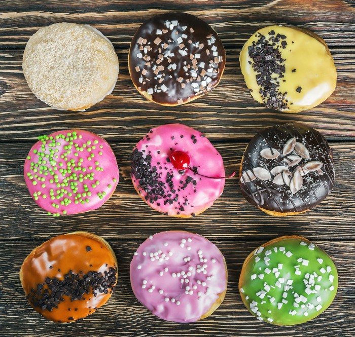 Assortment of colorful donuts on a wooden table