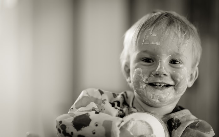 Boy with yogurt on his face smiling