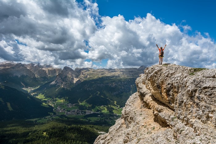 Woman on a mountain peak overlooking a valley