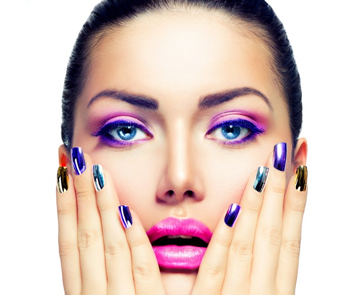 Woman with vibrant makeup and metallic nails