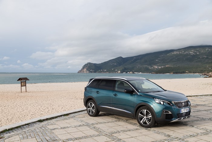Peugeot 5008 on a beach with mountains