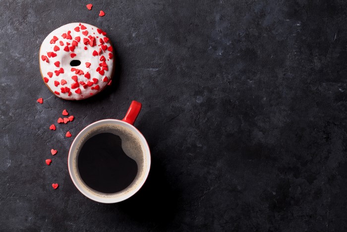 Donut with heart sprinkles and coffee cup