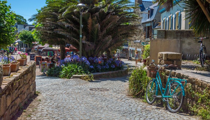 Street scene in Brehat, France with bicycles and palm trees