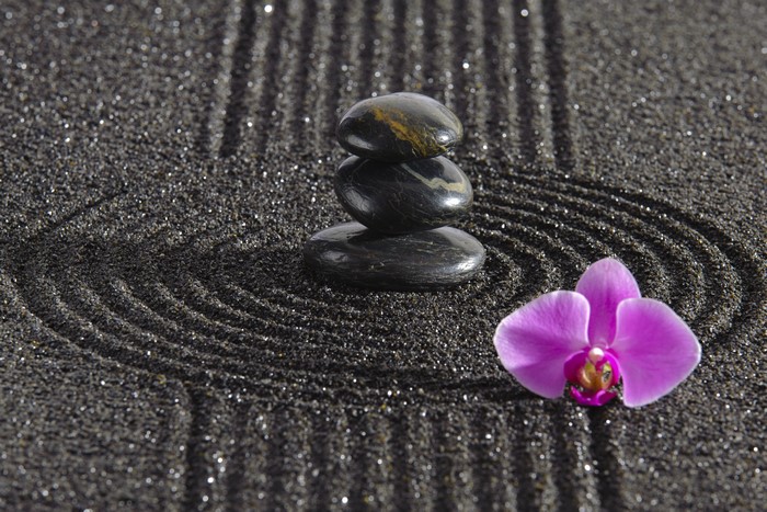 Zen garden with stacked stones and orchid