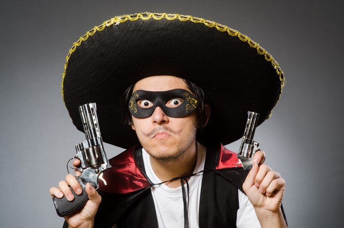 Man in sombrero and mask with pistols