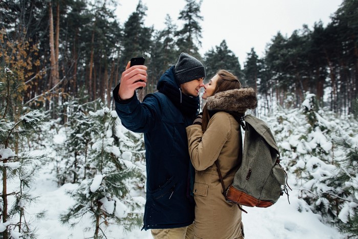 Couple taking a selfie in a snowy forest