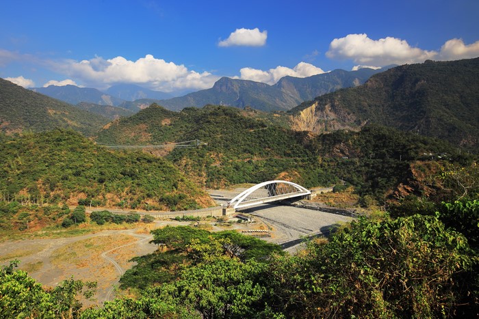 White arch bridge over a dry riverbed in Taiwan mountains