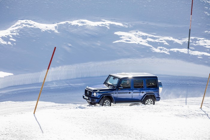 Blue Mercedes-Benz G-Class driving in snow