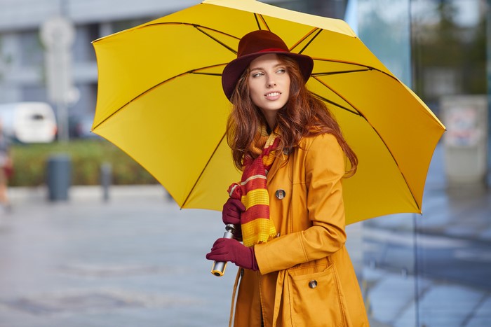 Redhead girl with umbrella and hat