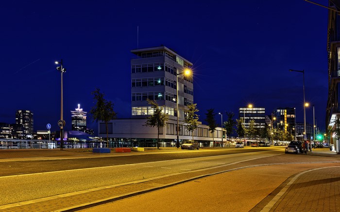 Amsterdam cityscape at night with modern buildings and street lights