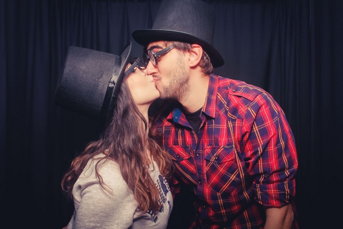Couple kissing wearing top hats and glasses