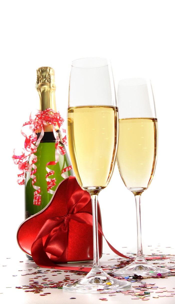 Champagne bottle, glasses, and heart gift with confetti