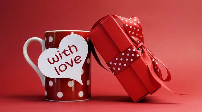 Red mug with white polka dots and a gift box with a bow