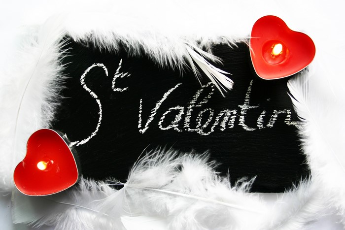 St. Valentine's Day chalkboard with heart candles and feathers