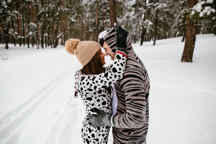 Couple in animal pajamas in a snowy forest