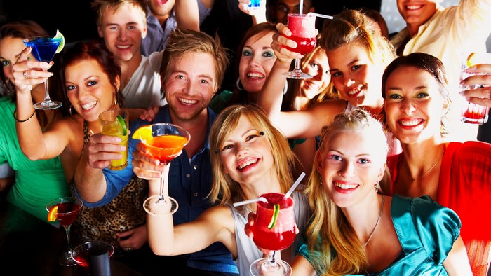 Group of smiling people holding cocktails
