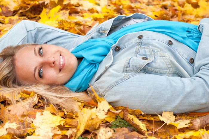 Woman lying in autumn leaves