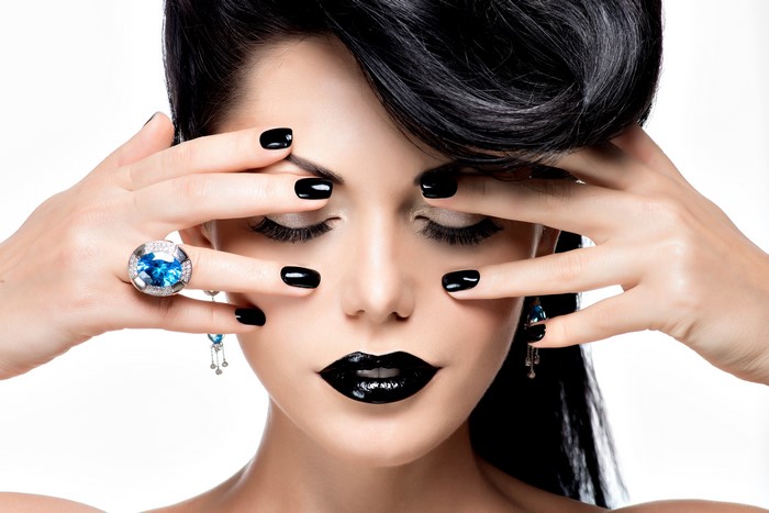 Woman with black nails and lipstick, wearing a ring