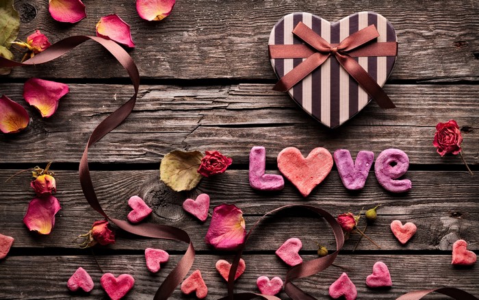 Love letters and heart-shaped gift on wooden planks