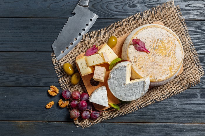 Cheese, Grapes, Olives, Nuts, and Knife on Wood