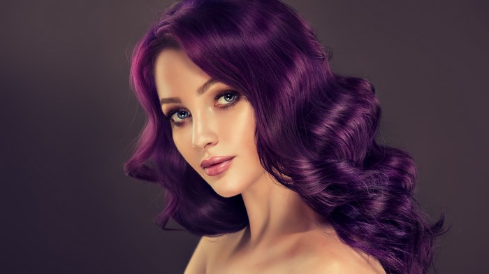 Woman with purple hair on gray background
