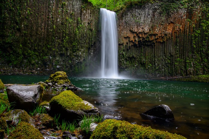Waterfall cascading over mossy rocks into a pool
