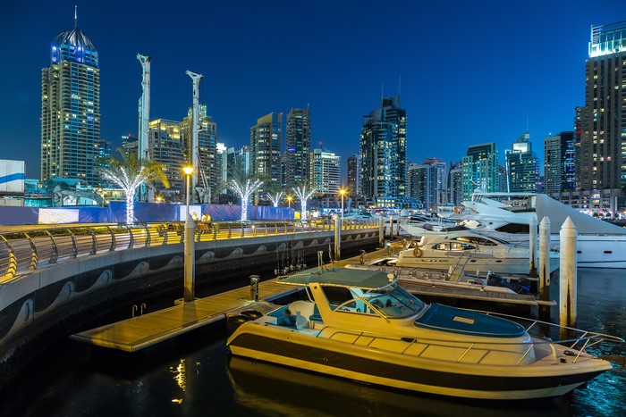 Dubai Marina at night with skyscrapers and yachts