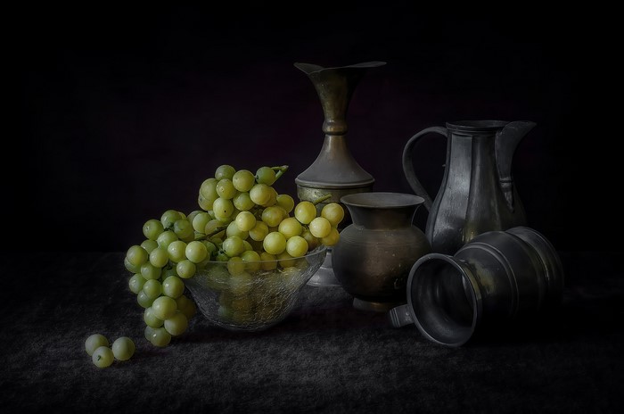 Still-life with grapes and antique metal jugs