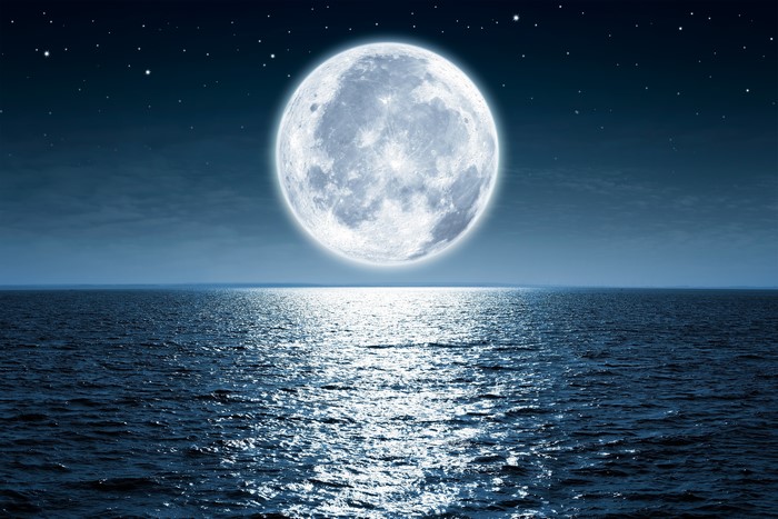Full moon over the ocean at night