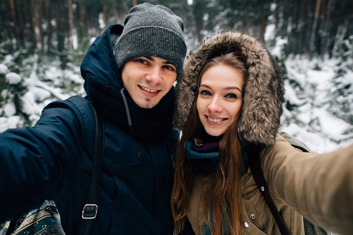 Couple taking a selfie in a snowy forest