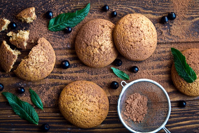 Cookies with currants and cocoa powder on wood
