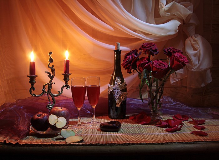 Romantic still life with roses, candles, and wine