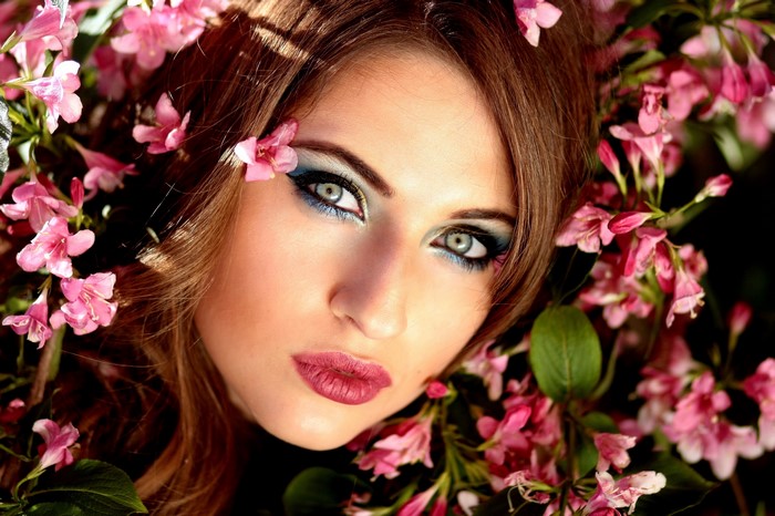 Woman with pink flowers and blue eye makeup