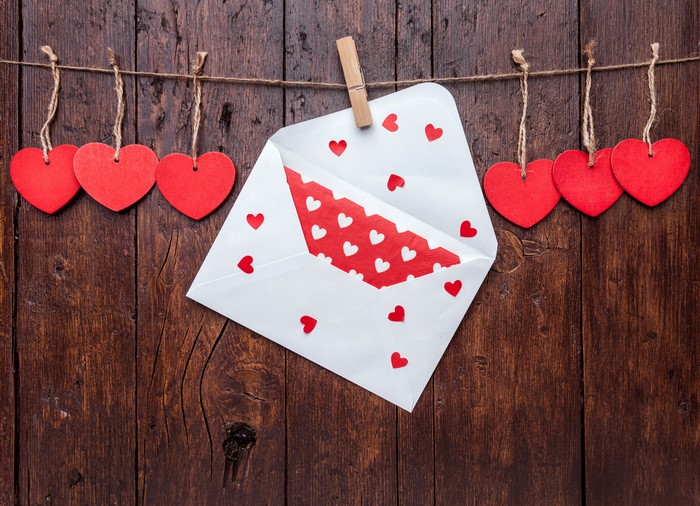 Valentine's Day hearts and envelope on wood