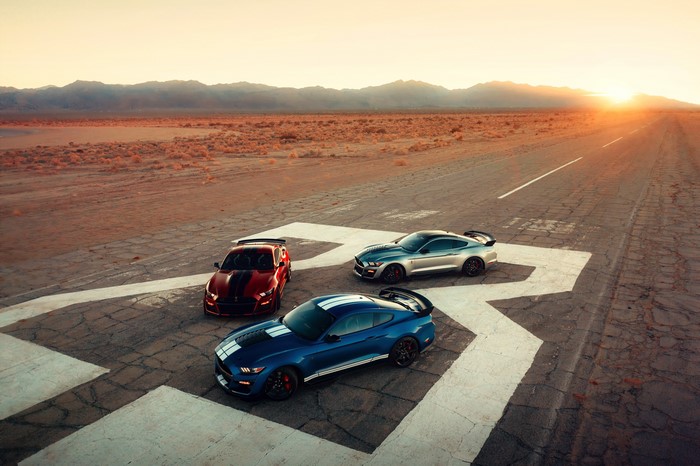 Three Ford Mustang Shelby GT500 cars on a road