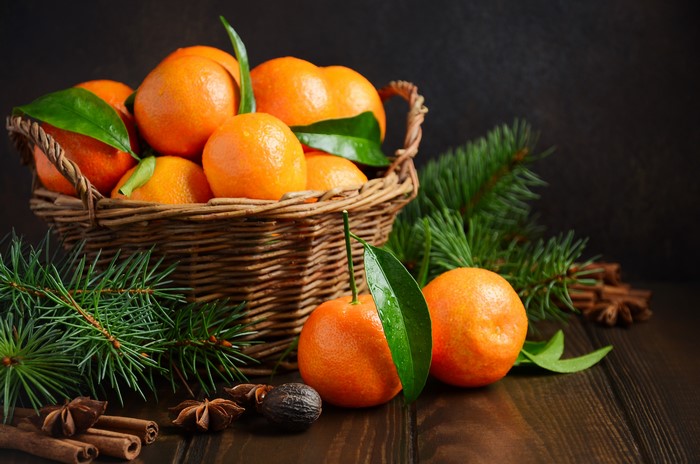 4K Mandarines in a Wicker Basket with Pine Branches